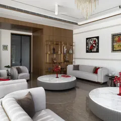 A view of the living room highlighting the curated art and a bespoke brass shelving unit. We work closely with clients to integrate their personal collections, making each space a true reflection of their identity.