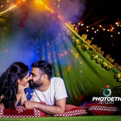 A romantic and cozy pre-wedding shoot inside a beautifully lit tent at night. The fairy lights and smoke create a dreamy, intimate atmosphere.