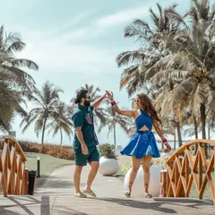 The couple shares a dance on a wooden bridge surrounded by palm trees, capturing the romantic and relaxed vibe of a Goa destination wedding.