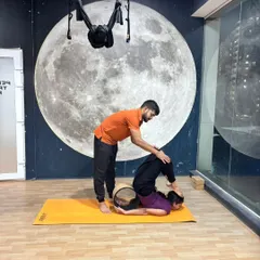 Here, I am assisting a student with a deep, wheel-assisted backbend. This hands-on support helps her relax into the stretch and safely increase spinal flexibility.