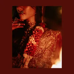 A cinematic bridal portrait lit by fire. The warm, flickering light and deep red tones give this image of Tvisha a mythical and powerful energy.