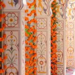 A detailed view of the hand-painted pillars at the entrance. The Mughal-inspired motifs and garlands of fresh marigolds showcase our commitment to authentic and artistic details.