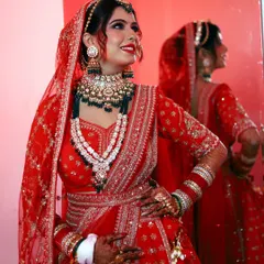 A full-length view of our senior artist's work on this gorgeous bride. The makeup is perfectly balanced with the heavily embroidered red lehenga and layered jewelry, creating a majestic bridal profile.