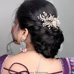 A trendy and intricate braided bun, perfect for a wedding or reception. The delicate hair accessory adds a touch of sparkle.