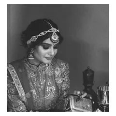 A timeless black and white portrait capturing the elegance of this vintage-inspired bridal look. The intricate embroidery on the high-neck blouse and the delicate matha patti are the stars of the show.