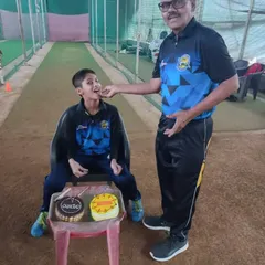A coach sharing a piece of birthday cake with Tanish. These small moments create a positive and encouraging environment for the kids.