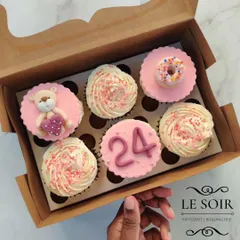 A sweet set for a 24th birthday celebration. This box features a mix of buttercream swirls and custom fondant toppers, including a tiny teddy bear holding a heart, the number 24, and a miniature donut.