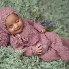 The sweetest dreams bring the sweetest smiles. I captured this moment of pure bliss with the baby dressed in a cozy, hand-knitted purple outfit, showcasing my gentle approach to posing sleeping newborns.