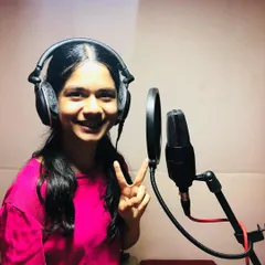 A student flashes a peace sign during her first studio recording session. It's a fun and exciting experience that builds confidence.