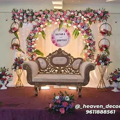 An elegant engagement stage featuring a delicate floral arch in pastel pinks and whites. We included a personalized sign with the couple's names, hanging floral hoops, and coordinated flower stands to complete this romantic look.