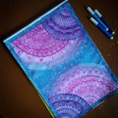 This is my 'Galaxy Mandala' series, where I blend intricate geometric patterns with the colors of deep space. Each section is carefully detailed with fine-line markers, transitioning from cosmic blues to vibrant purples and pinks to create a sense of depth and wonder.