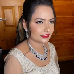 A pretty and glamorous look for a Sangeet night. This makeup features soft glitter eyeshadow, glowing skin, and a classic red lip, paired with a chic ponytail.