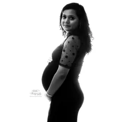 A simple yet stunning black and white profile shot. This high-contrast lighting technique creates a timeless silhouette that beautifully accentuates the baby bump.