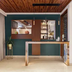 A suave bar takes up one corner of the living room. The bespoke bar counter features a black granite top and a tiled base, while the display behind hosts a collection of shot glasses from the clients' travels.