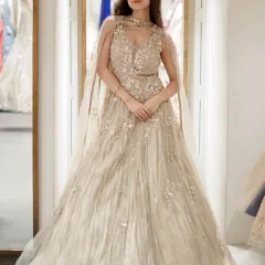This golden gown is pure magic, featuring a structured bodice and a flowing cape. The intricate beadwork and shimmering fabric make it a perfect outfit for a cocktail party or reception.