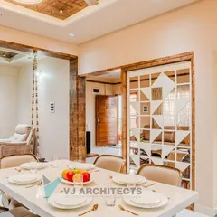 A view from the dining area into the living room of the "hodophile" couple's flat. The design uses a consistent warm, earthy palette and features a traditional Indian swing, blending comfort with cultural elements.