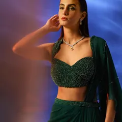 A closer look at the emerald green draped saree set. The styling focuses on the intricate beadwork of the bustier and the graceful fall of the fabric.