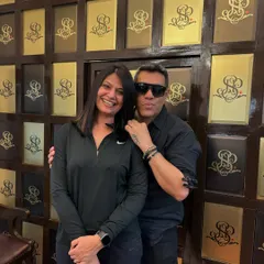 It's all about the final result. A happy client and I pose against our signature logo wall after her service. Ensuring you feel amazing is what we do best.