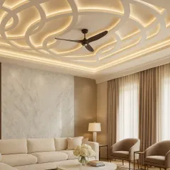 A flowing, wave-patterned false ceiling design that incorporates a ceiling fan seamlessly. The integrated lighting follows the curves, adding a sense of movement and sophistication to the room.
