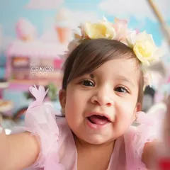 A joyful close-up of the birthday girl, reaching for the camera with a huge smile. This captures the playful and interactive nature of a one-year-old.