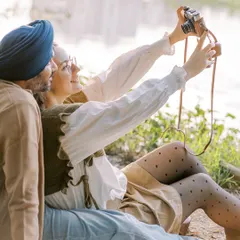 A fun, candid moment where the couple takes a selfie with a vintage film camera. It shows their playful side and their shared love for creating memories together.