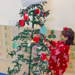 A young participant helps decorate our Christmas tree. Group activities like this foster a sense of community and shared joy during our holiday events.