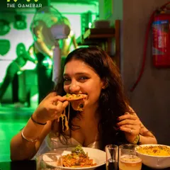 That perfect cheese pull. A guest enjoying a slice of our delicious pizza during our new menu launch party.
