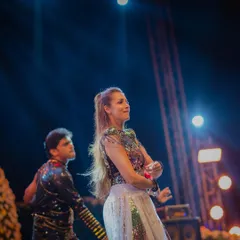 A couple performs a choreographed dance on stage. We can facilitate everything from private lessons to full-scale Sangeet choreography.