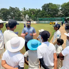 A coach engages with a group of young players in a circle. These sessions are for discussing tactics, reflecting on performance, and building a strong mindset.