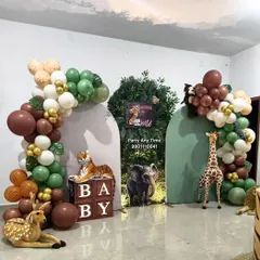 For this jungle theme, I used 'BABY' blocks and various animal props to create a setup perfect for a first or second birthday. The green and brown balloon arch completes the forest look.