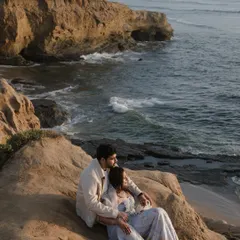 Overlooking the vast ocean from a rocky cliffside. This dramatic, scenic shot is perfect for adventurous couples who want their pre-wedding photos to have a sense of scale and wonder.