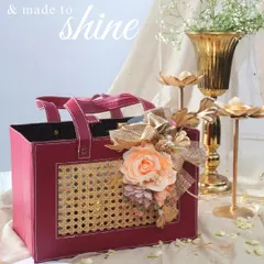 This radiant hamper in a deep red leatherette and cane bag is designed to shine. It's a thoughtful and graceful gift, adorned with a peach floral arrangement, perfect for lighting up your Diwali celebrations.