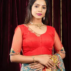 A model pairs a vibrant red blouse with a simple, elegant choker and bracelet. This shows how minimalist jewellery can beautifully accessorize a brightly colored outfit.
