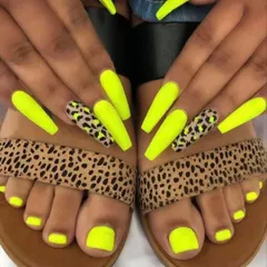 A bold and coordinated look with neon yellow nails and leopard print accents, matching the pedicure and even the client's sandals.