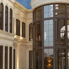 A detailed view of the curved glass facade and window articulation, demonstrating precision in execution and material selection.