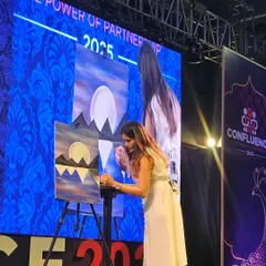 On stage, guiding a large corporate event. You can see me on the big screen, demonstrating the painting steps. Managing the technical aspects, like live video feeds and microphones, is a key part of scaling up to larger venues.