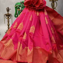 This vibrant pink Kanjivaram silk saree is pure celebration. The body is adorned with gold buttas, and the rich zari border makes it a perfect choice for weddings and festive occasions.