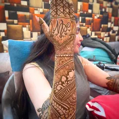 A full-arm bridal design shown from the side. This view highlights the seamless flow of patterns from the wrist to the elbow, featuring a custom initial monogram on the back of the hand.