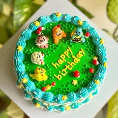 Pokémon dream cake alert! This custom cake features edible Pokémon characters like Pikachu and Charmander crafted with buttercream, sitting on a vibrant green field.