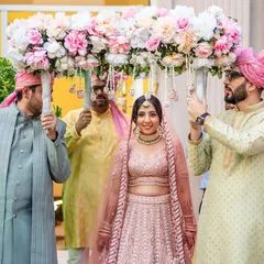 A beautiful bridal entry under a phoolon ki chadar. The bride's happy expression and the elegant floral arrangement make this a picture-perfect moment.