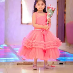 The birthday girl holding a bouquet of flowers, looking like a little princess.