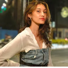 A night portrait taken on the streets of Mumbai for a realme campaign. The subject is lit by the ambient city lights, with the background blurred to create a beautiful bokeh effect and keep the focus on her expression.