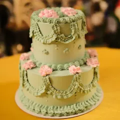 A stunning two-tier vintage style cake for an engagement. I used a classic piping technique to create the intricate buttercream frills and added delicate pink flowers for a soft, romantic look. These Lambeth style cakes are very popular for elegant events.