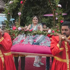 The bride's procession is a celebration in itself. Here, the bride is carried in on a floral palanquin, surrounded by her family and friends, creating a moment of joy and anticipation.