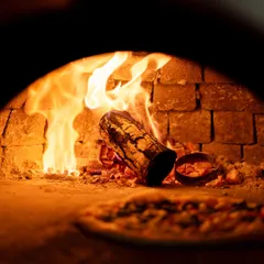 The heart of my pizzeria is the wood-fired oven. The dancing flames and intense heat are what give my pizzas their signature smoky flavor and perfectly blistered crust. It's the traditional Italian method that you can taste in every single bite.