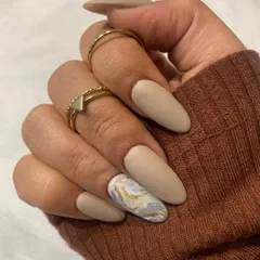 Matte it is. This beautiful set features a soft, beige matte polish with a single accent nail in a sophisticated marble design.
