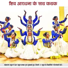 A newspaper clipping featuring the dance troupe in action. The caption reads "Kathak with devotion to Shiva," and the dancers' formation, enhanced by the flowing white skirts and royal blue blouses, is breathtaking.