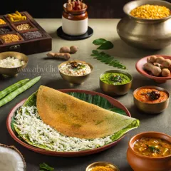 A modern take on a dosa, filled with cheese and styled with fresh ingredients. The shot is composed to highlight the beautiful textures and colors of the dish.