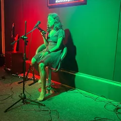 A performer shares her art, whether it's a song or spoken word poetry, under the lights of our Open Mic stage. We encourage all forms of vocal expression.