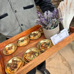 A tray of our delicious garlic cheese bread, served in individual golden dishes. This image shows our professional server presenting the appetizers, highlighting our courteous and well-groomed staff.